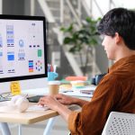 A web designer works at his desk on a new website design.