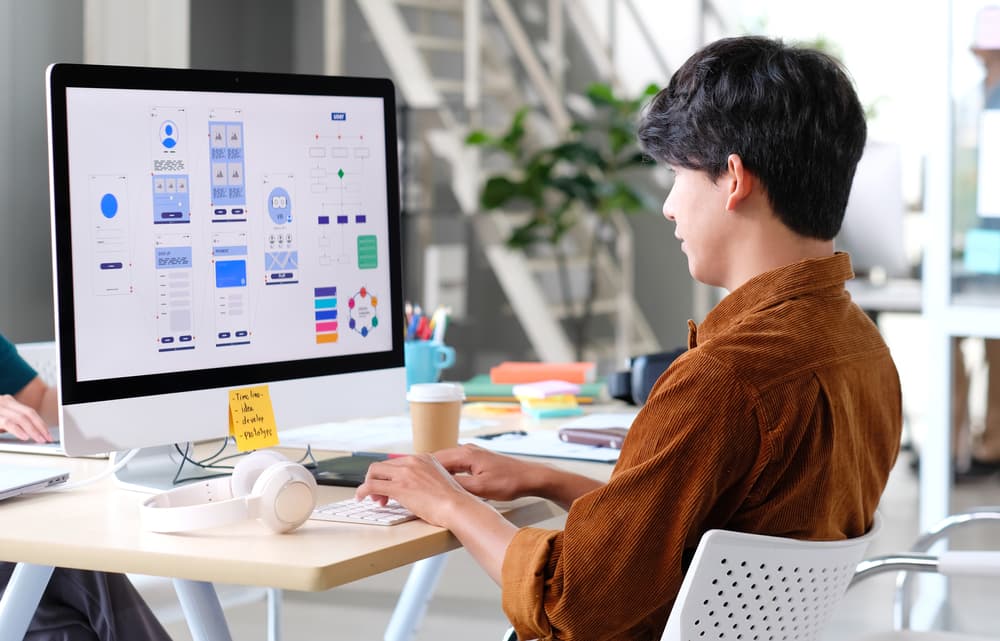 A web designer works at his desk on a new website design.