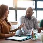 A communications manager meets with her team in an office conference room to discuss crisis communications strategy.